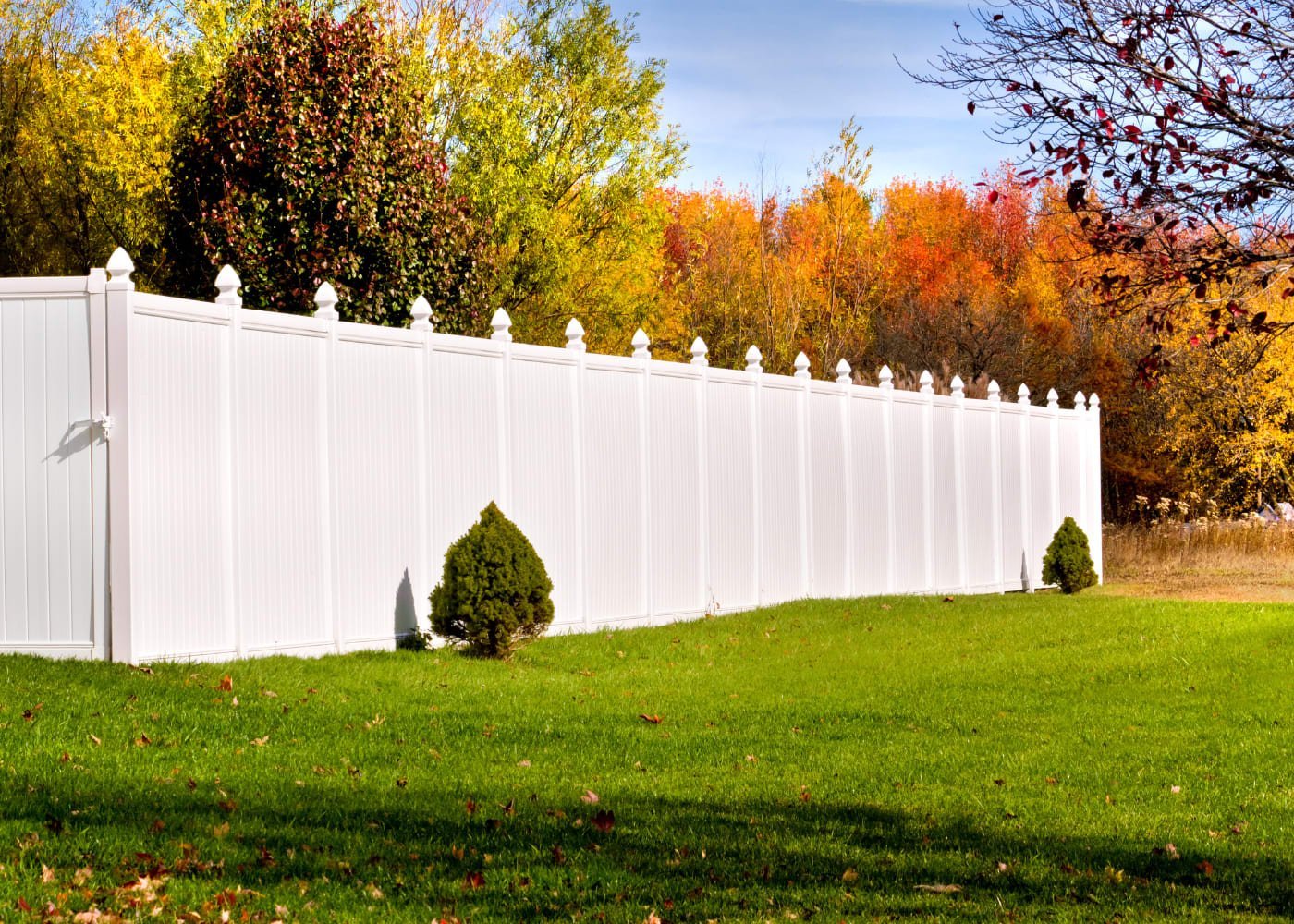White vinyl privacy fence beside a landscaped yard