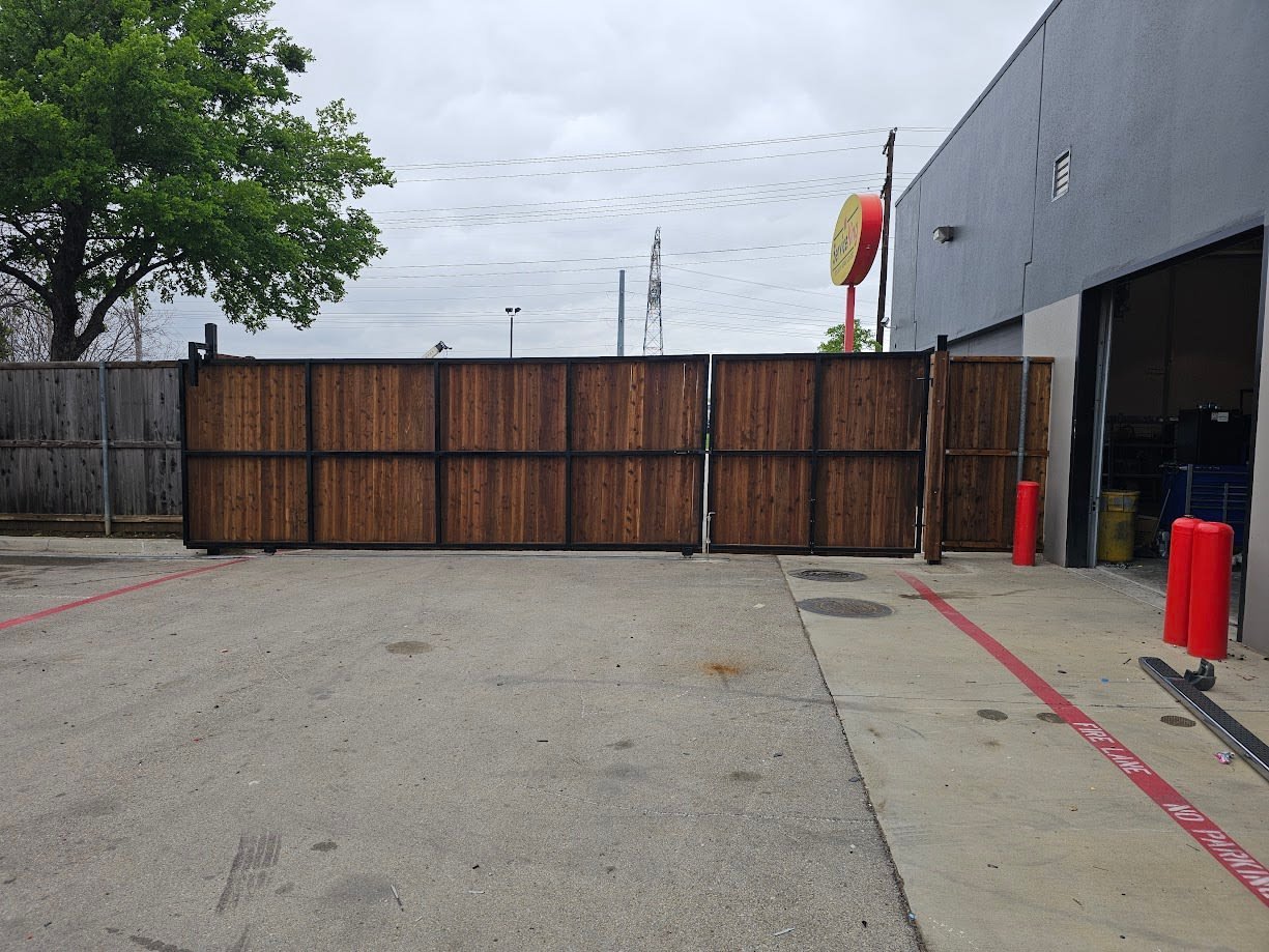 Black metal electric sliding driveway gate across a residential entrance